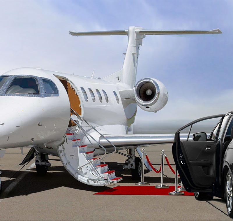 Private jet and black car waiting on landing strip in airport